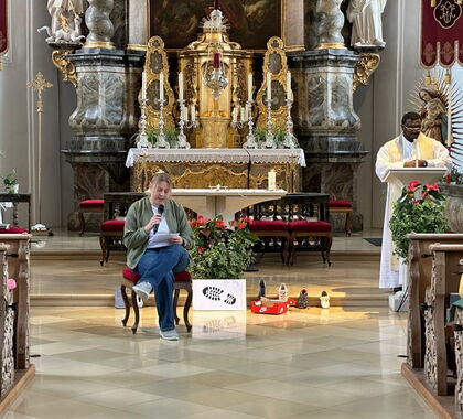 Eine Frau spricht in ein Mikrofon vor dem Altar