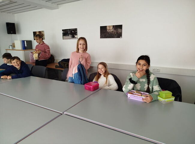Schüler sitzen gemeinsam an einem Tisch mit Brotzeit
