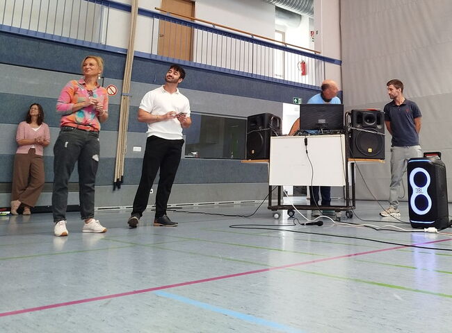 Eine Gruppe Moderatoren steht in der Turnhalle