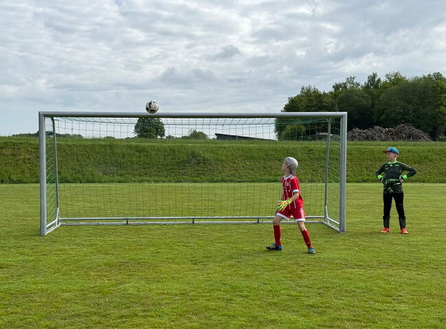 Ein Fußball fliegt in Richtung Tor
