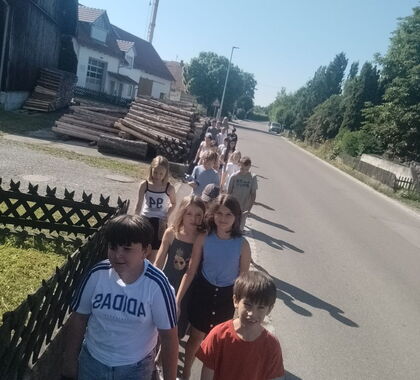 Schüler laufen auf dem Bürgersteig an einer Straße entlang