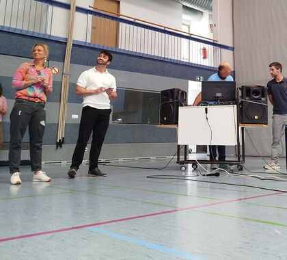 Eine Gruppe Moderatoren steht in der Turnhalle