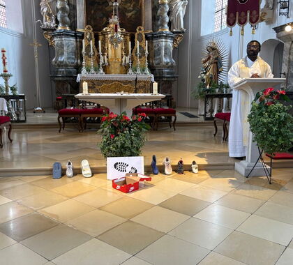 Schuhe sind vor einem Altar aufgestellt