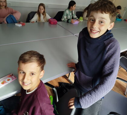 Schüler sitzen gemeinsam an einem Tisch mit Brotzeit