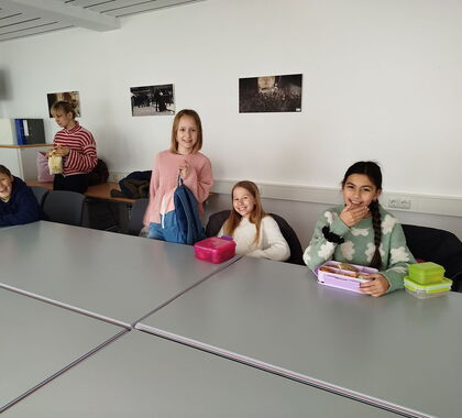 Schüler sitzen gemeinsam an einem Tisch mit Brotzeit